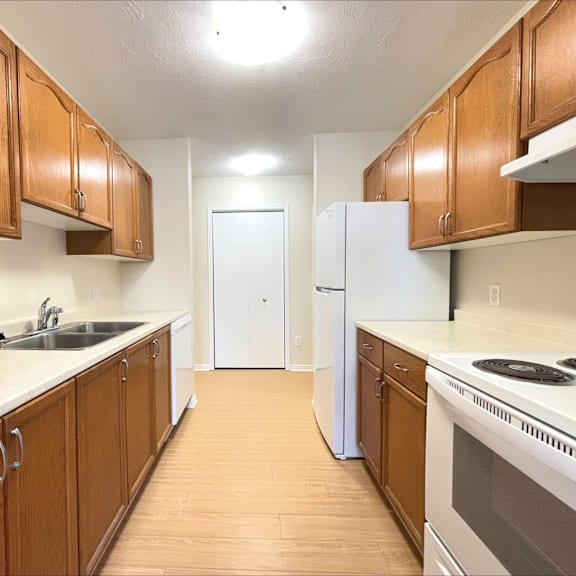 a kitchen with wooden cabinets and white appliances.