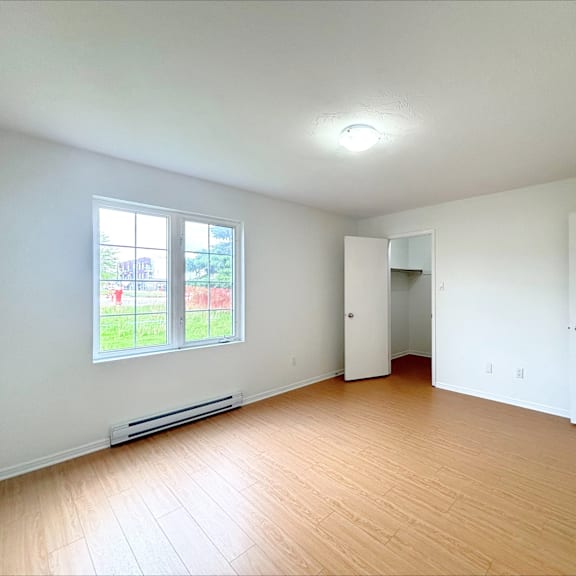 a room with a window, a door, and a wall-mounted shelf.