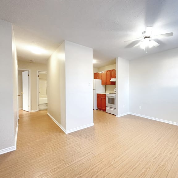 a room with a ceiling fan and wooden flooring.