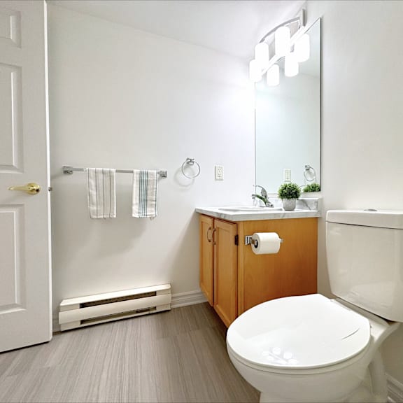 a white toilet sits in a bathroom with a white door and a mirror.