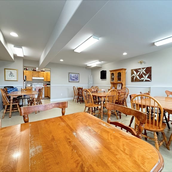 a room with wooden chairs and tables.