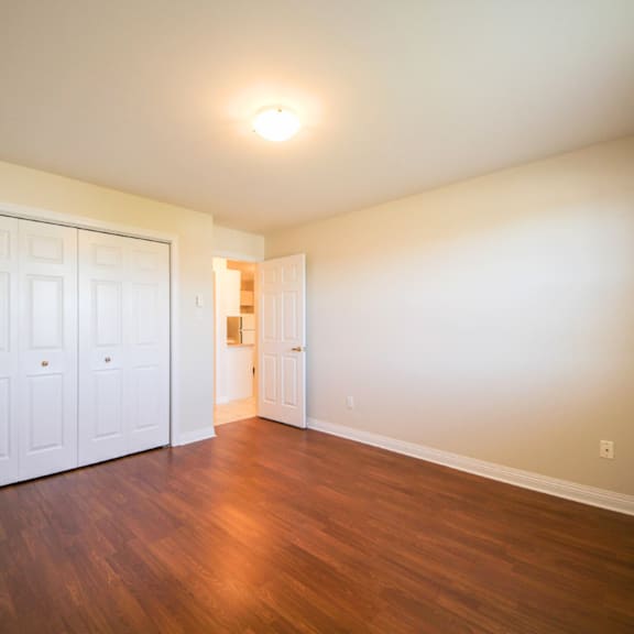 a room with a white door and wooden floors.
