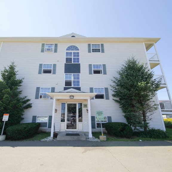 a two-story building with a white facade and a covered entrance.
