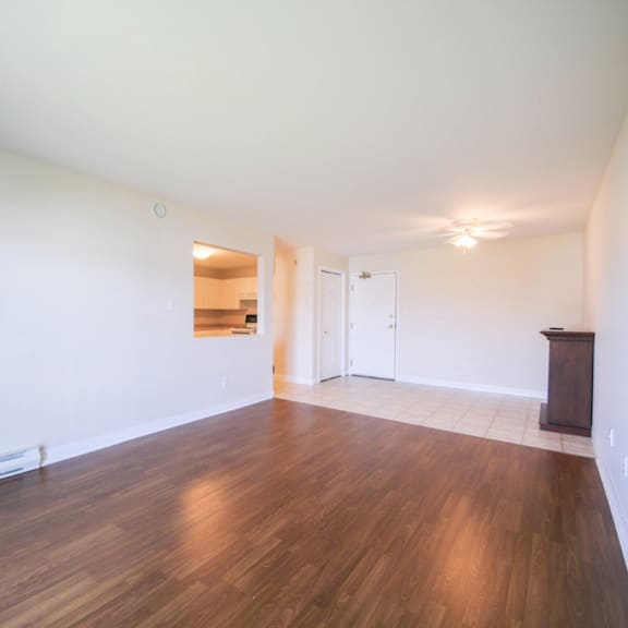 empty room with wooden floors and white walls.