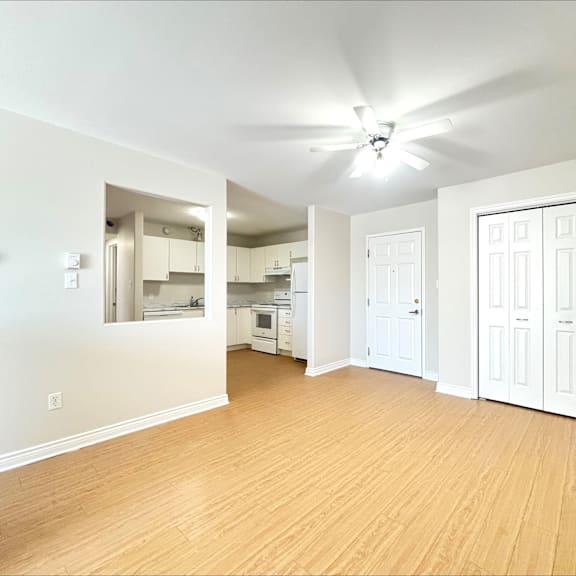 a room with a ceiling fan and wooden flooring.