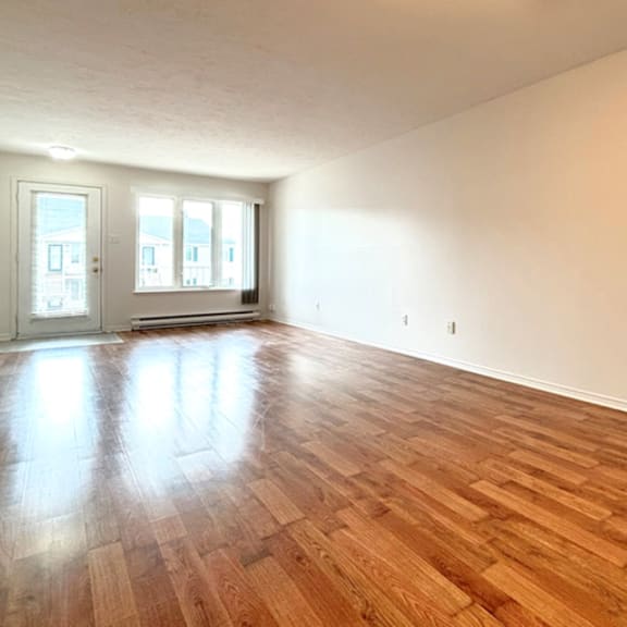 a room with wooden flooring and two doors.
