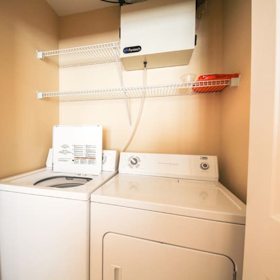 a white washing machine and dryer in a small laundry room.