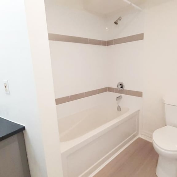 a white toilet sits next to a bathtub in a bathroom.