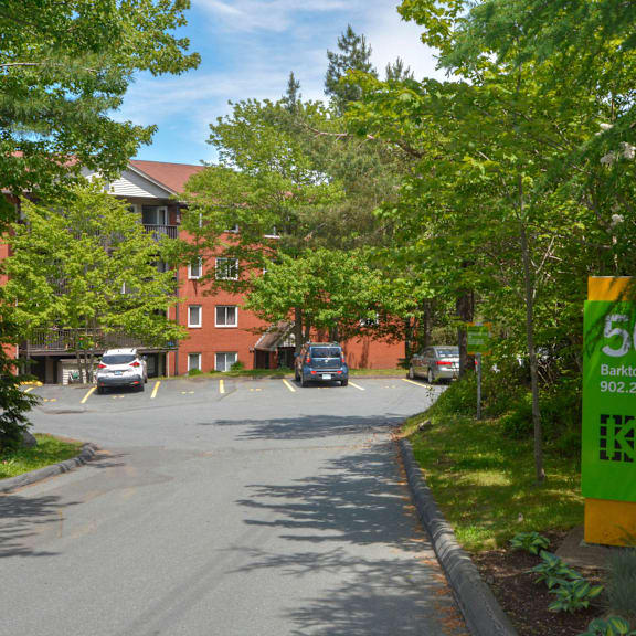 a green and yellow sign for killam apartment rent is on the side of a road.