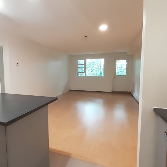 a room with a black countertop and wooden flooring.