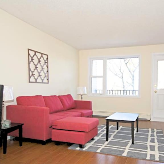 a red couch in a living room with a small table in front of it.