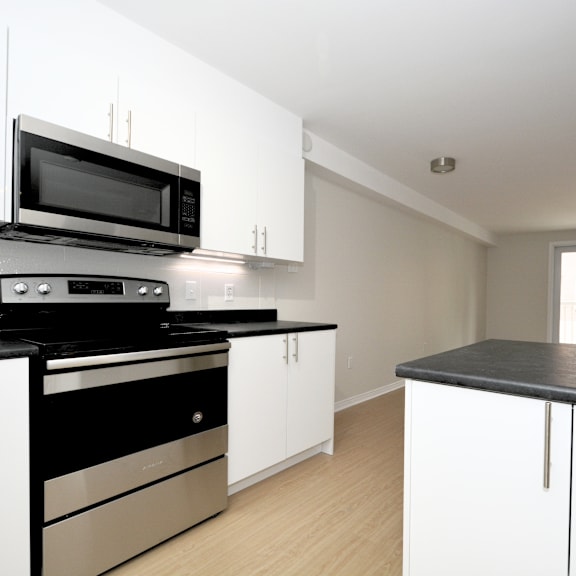 a modern kitchen with black and white appliances and cabinets.