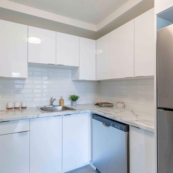 a kitchen with white cabinets and a stainless steel refrigerator.