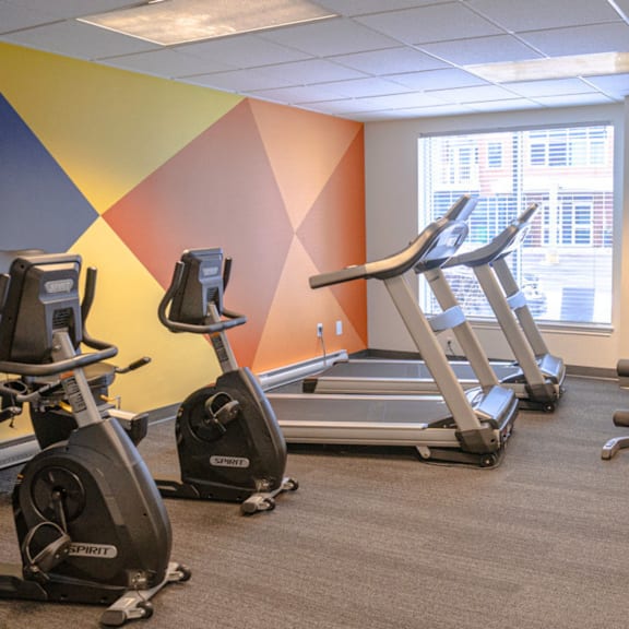 a gym with exercise equipment including treadmills and stationary bikes.