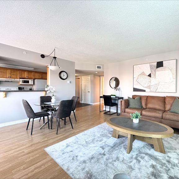 a modern living room with a grey rug and a brown couch.