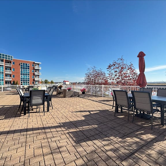 a patio with a table and chairs overlooking a body of water.