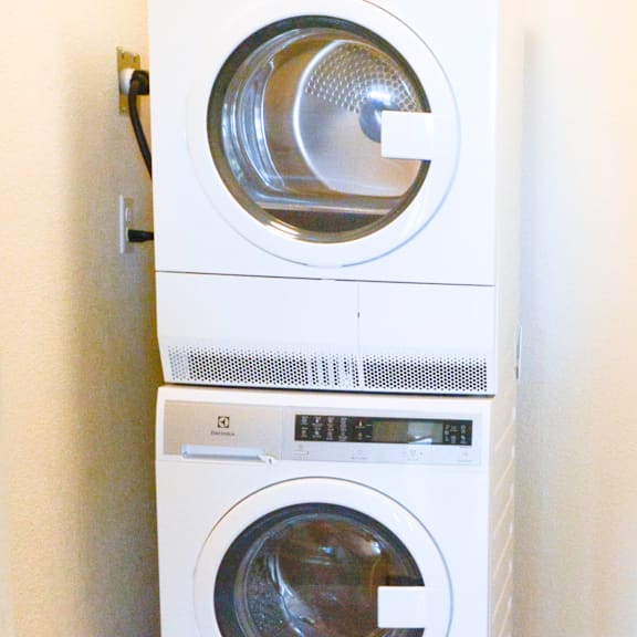 a white washing machine is stacked on top of another white washing machine.