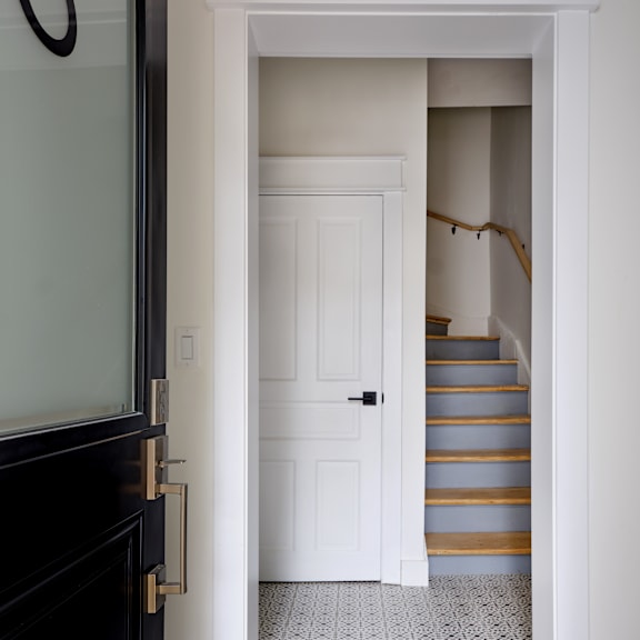 a white door is open to a staircase.