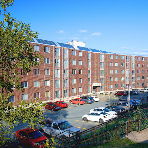 a parking lot in front of a red brick building.