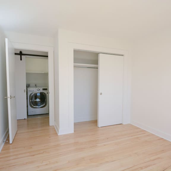 a white room with a washing machine in the doorway.