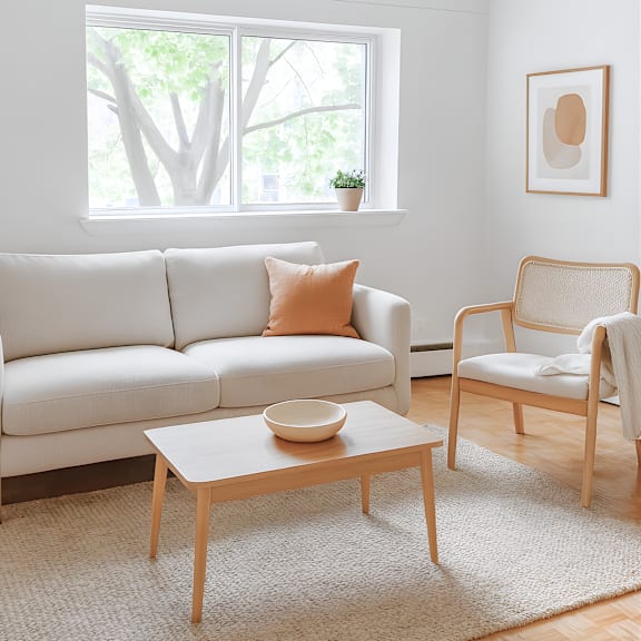 a white couch sits in a living room with a wooden coffee table in front of it.