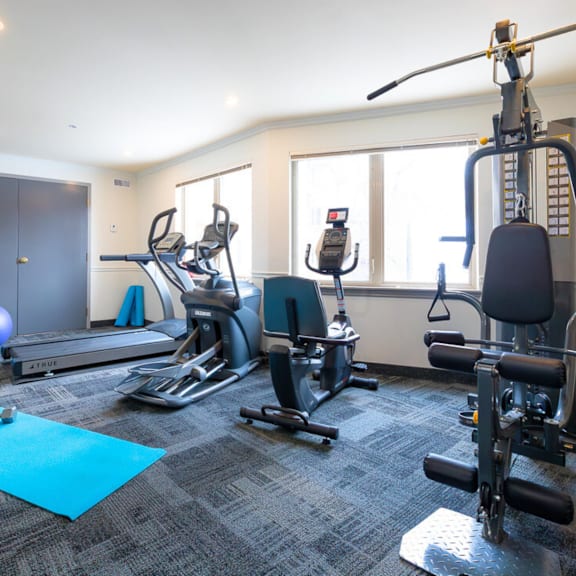 a gym with a variety of equipment including treadmills, exercise bikes, and weight machines.