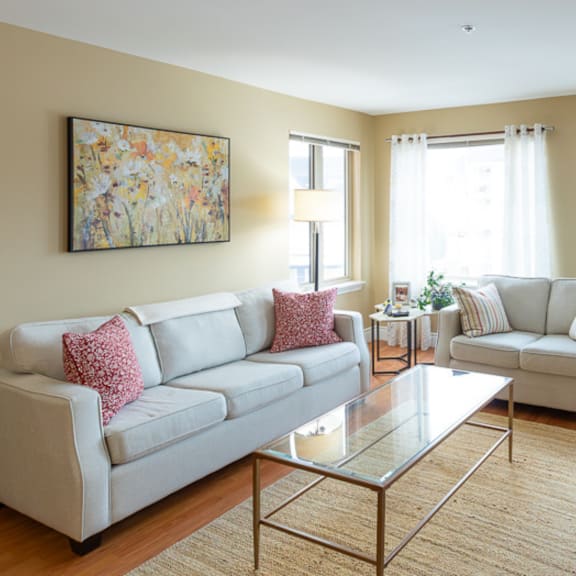 a living room with a large painting on the wall and two couches.