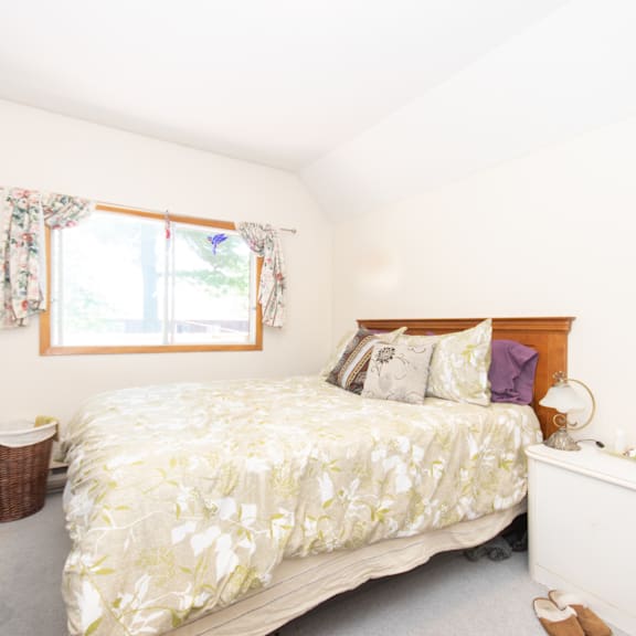 a bedroom with a large bed and a window with curtains.