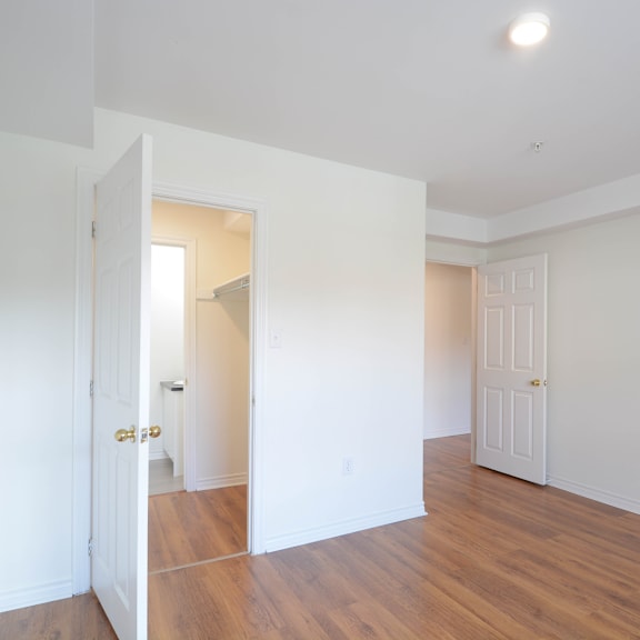 a room with a white door and a wooden floor.