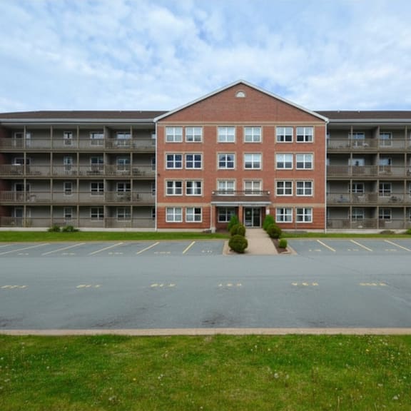 a red brick building with a parking lot in front.