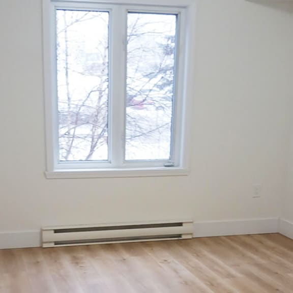 a room with a window and a radiator on the floor.