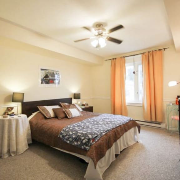 a bedroom with a large bed and a ceiling fan.