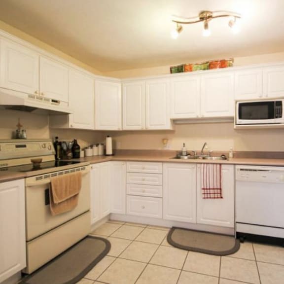 a kitchen with white cabinets and appliances.