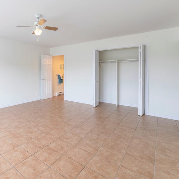a room with a ceiling fan and tile flooring.