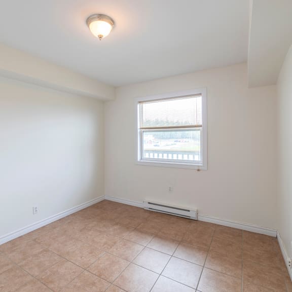 a room with a window and tiled floor.