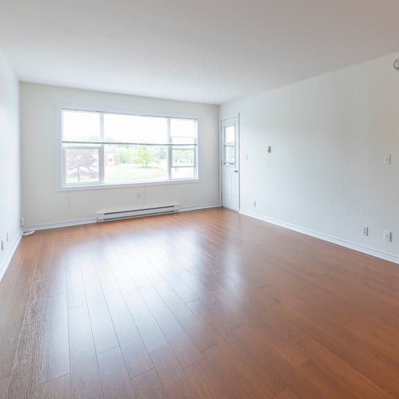 a room with wooden flooring and a large window.