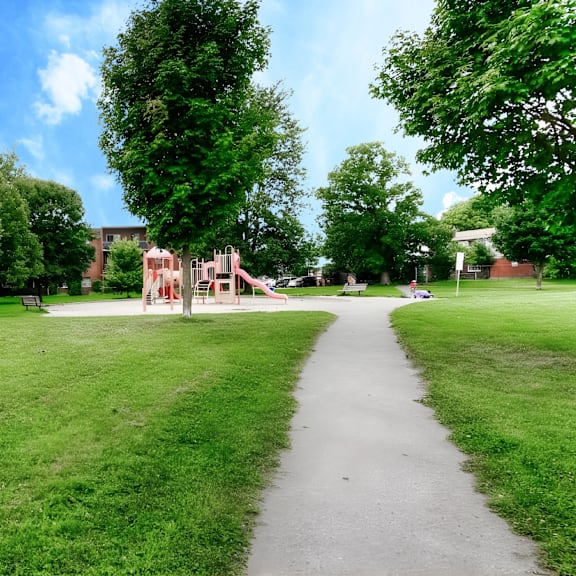 a playground with a slide is in the middle of a grassy area.
