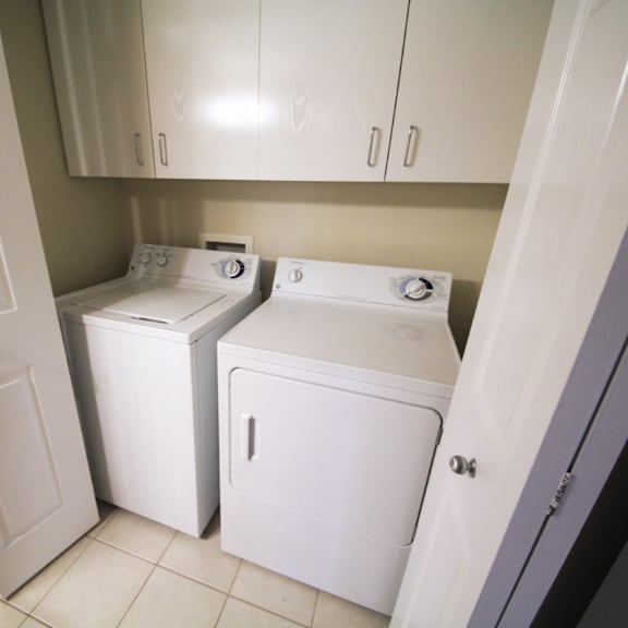 a white washing machine and dryer in a small laundry room.