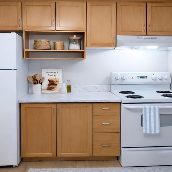 a kitchen with a white stove and wooden cabinets.