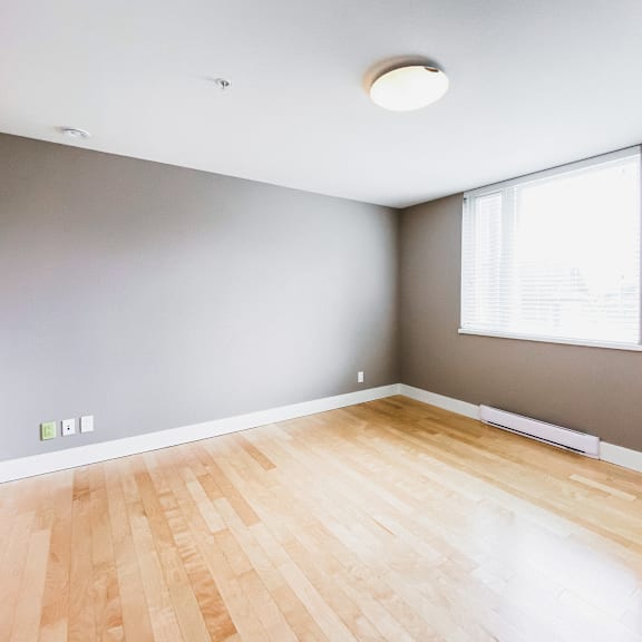 a room with a wooden floor and a window.