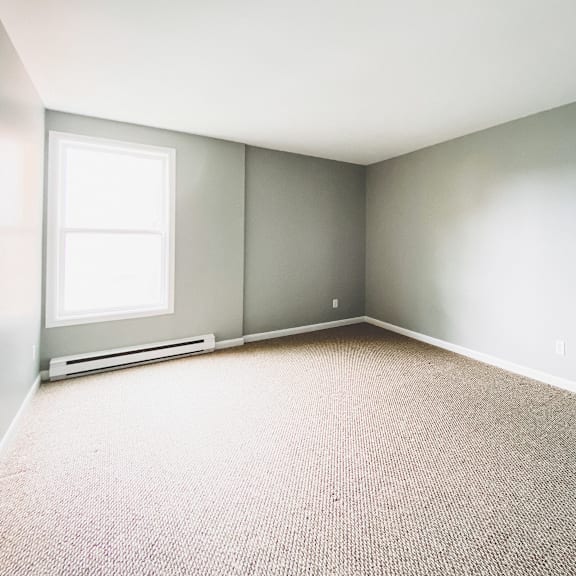 a room with a window and a carpeted floor.