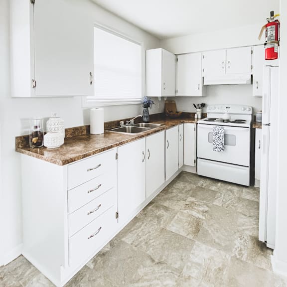 a kitchen with white cabinets and a white stove.