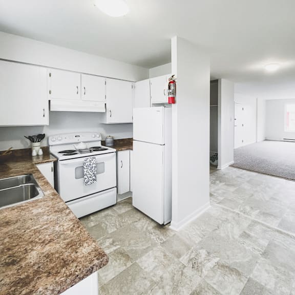 a kitchen with white appliances and a granite counter.
