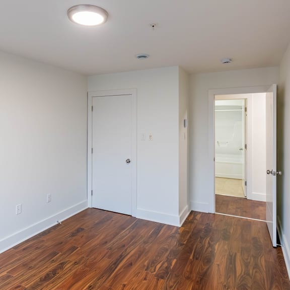 a room with a white door and a wooden floor.