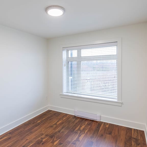 a room with a window and wooden flooring.