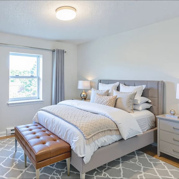 a bedroom with a large bed and a bench in front of it.