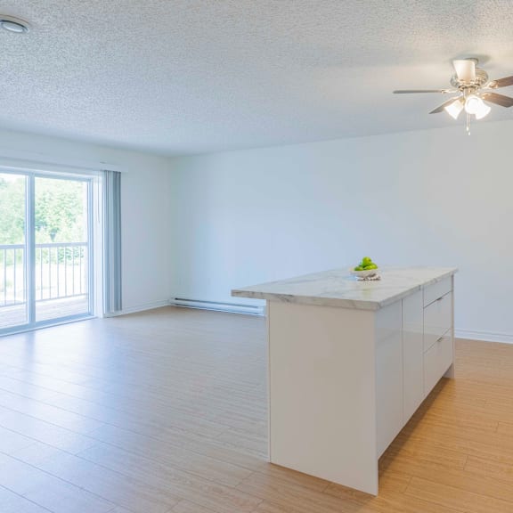 a kitchen with a marble countertop and a ceiling fan.