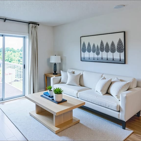 a living room with a white couch, a wooden coffee table, and a painting on the wall.