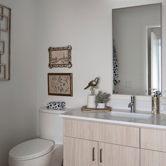 a bathroom with a toilet, sink, and mirror.