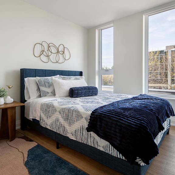 a bedroom with a large bed and a blue rug.